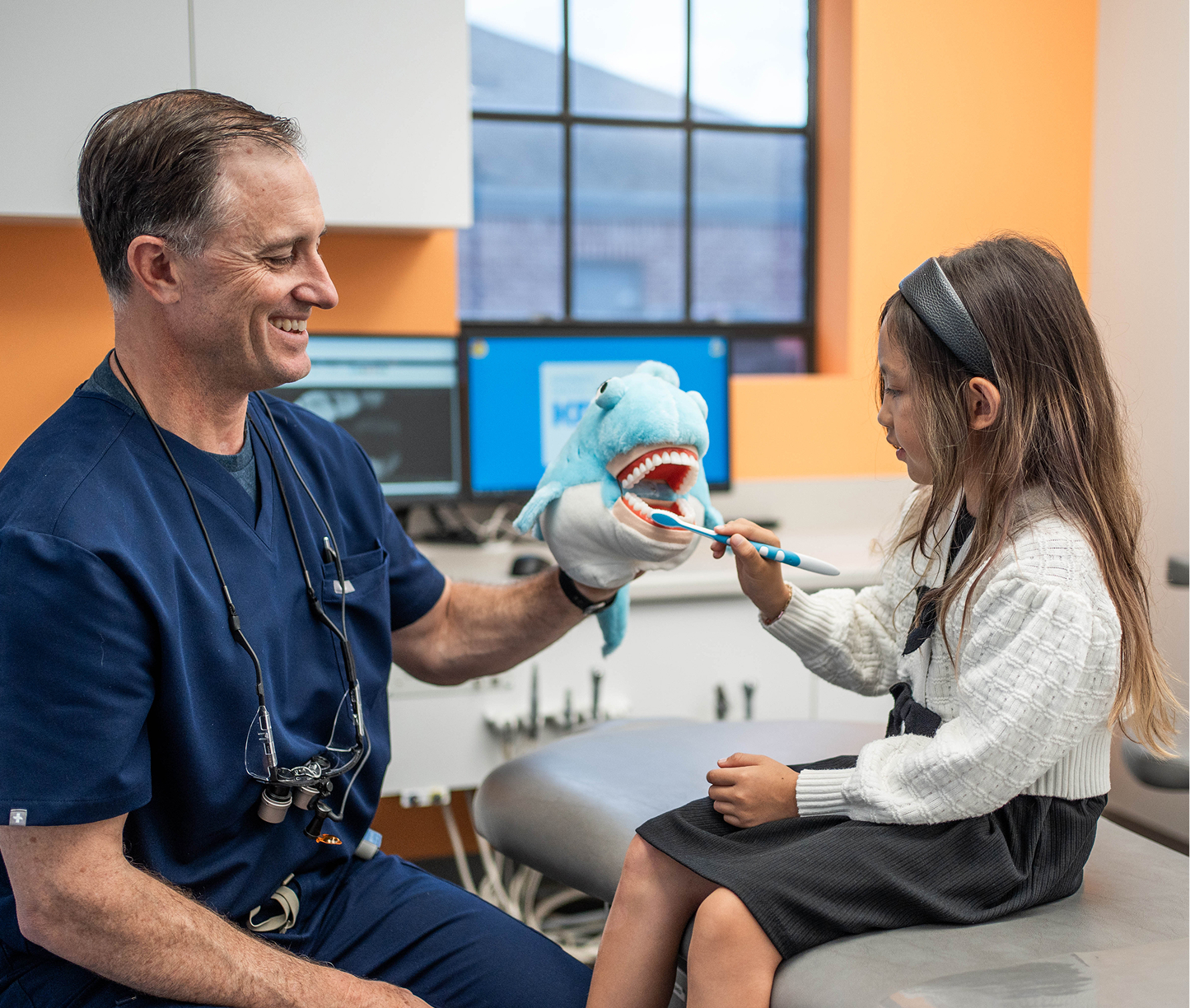 Team member kneeling to greet a young patient